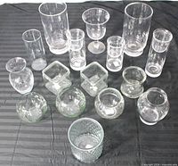 All 16 clear glass vessels arranged