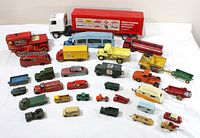 All 32 die-cast vehicles arranged on white background, showing variety and condition