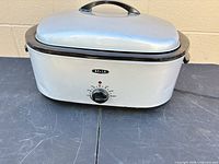 Front view of silver Bella roaster oven with lid and control knob