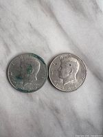 Obverse of both Kennedy half dollars showing dates and surface wear