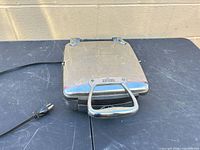 Closed waffle maker top view with power cord