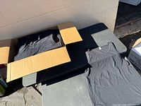 Open box showing stacked black tank tops