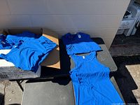 Stacks of royal blue tank tops on tables and in box