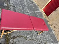 Full view of burgundy massage table unfolded