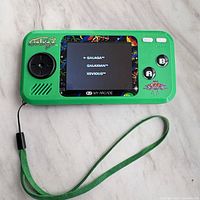 Front view showing screen, controls, graphics, wrist strap attached