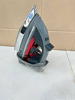 Left profile showing grey handle, red tank, chrome soleplate, coiled cord