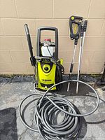 Full view of pressure washer with hose and accessories
