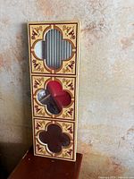 Full view of mirror showing three quatrefoil panels and decorative frame