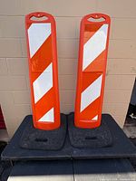 Front view of both orange vertical traffic panels on their black rubber bases