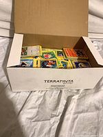 Open cardboard box filled with assorted Pokémon cards