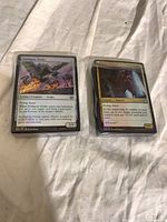 Two sleeved foil Magic: The Gathering cards displayed face up
