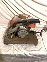 Full saw on rusted base, blade guard visible