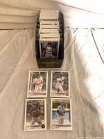 Stack of sleeved cards in box with several visible fronts