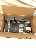 Open cardboard display box showing stacks of Flesh and Blood cards