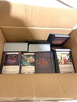 Open cardboard box containing multiple stacks of Flesh and Blood cards, backs and some fronts visible