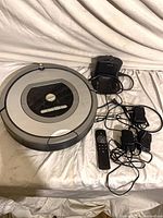 Roomba vacuum, dock, remote and adapters overall view