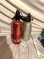 Front view of both syphons: red with stripes and plain silver