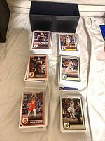 Stacks of Panini Hoops basketball trading cards with black storage box