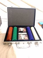 Open aluminum case displaying chip stacks, two decks and dice