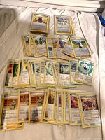 Full lot of sleeved reverse-holo trainers and energy cards spread out on bed