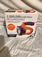 Front view of retail box showing image of orange/black rechargeable spotlight and 2,000,000 candle power specification