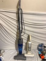 Full view of both Shark vacuums standing upright