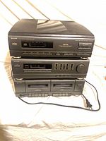 Front view of stacked Sharp CD changer, amplifier/tuner, cassette deck