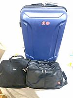 Overall view showing blue suitcase and two black briefcases