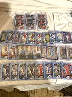 All 33 holographic cards laid out on bed in protective holders