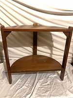 Front view of demilune side table showing two tiers and overall structure