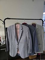 Front view of three Simpson Sin Tailor blazers on rack