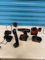 Group shot of cordless drill, screwdriver, battery packs and chargers