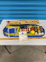 Full set laid out: mallet handles, mallet heads, balls, wickets, stakes, bag, manual