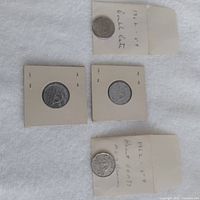 Overview of four Canadian nickels: two in flips, two loose with sleeves