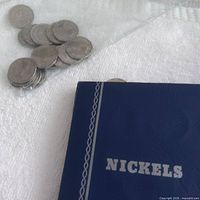 Blue album cover marked NICKELS and bag of loose coins