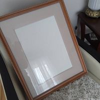 Full view of wood picture frame with mat and glass