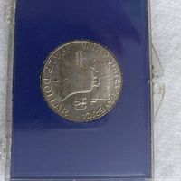 Reverse of 1963 Franklin half dollar showing Liberty Bell inside blue plastic holder