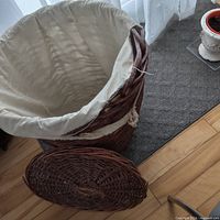 Hamper interior showing cream cloth liner torn along rim