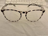 Front view of spotted blue light glasses with keyboard blurred in background