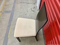 Side view of one dining chair showing curved backrest and upholstered seat