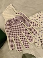 Pair of white cotton gloves with purple PVC dots