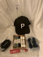 Group shot of hat, belt, boxed laces, blue laces pack, red shoehorn