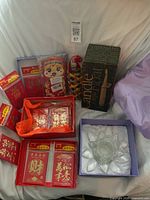 Group view showing red envelopes, woven basket, boxed floating candle, and boxed lotus candle holder