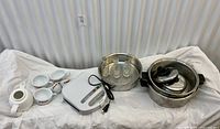 Group shot of sandwich press, mugs, stainless pans, lids, teapot