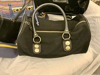 Front close-up of Joe Fresh barrel bag, partial view of backpack, patent bag and pencil case