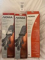 Front view of three boxed NOMA surge protectors