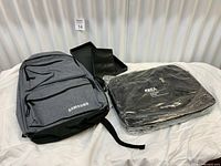 Overall view of Samsung backpack, boxed passport holder, and wrapped OREA laptop bag