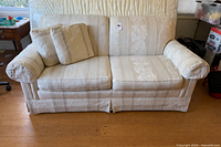 Front view of cream Thomasville loveseat with two throw pillows