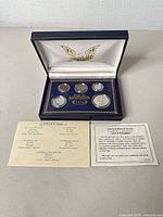 Overall view of open presentation case showing all five coins and inserts