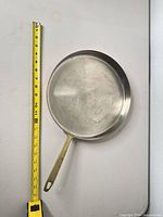 Top view showing stainless interior surface and measuring tape indicating 12 in diameter